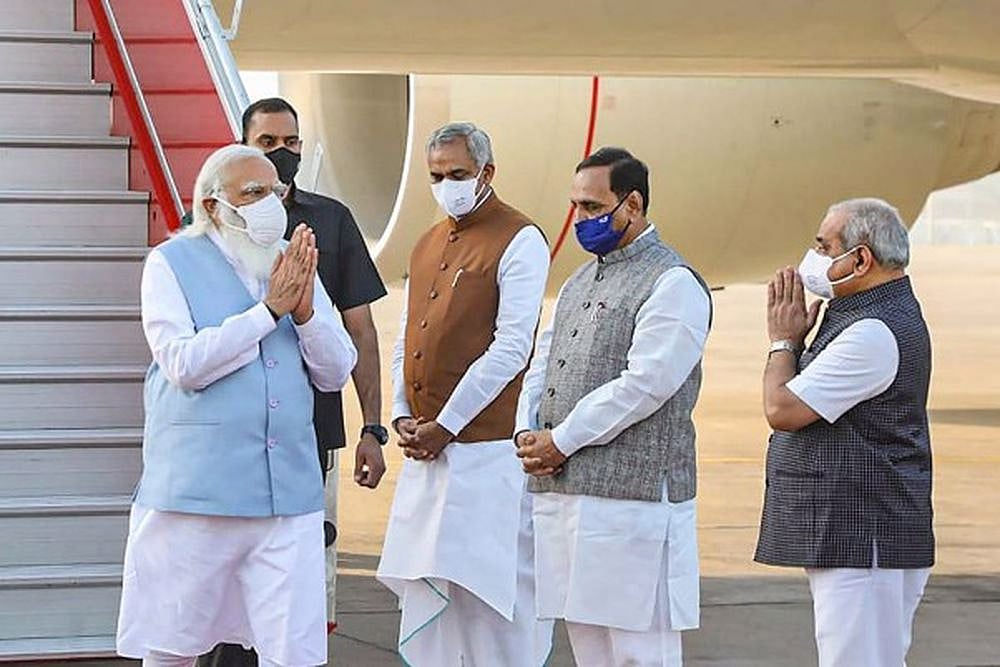PM Modi being received by Gujarat Governor Acharya Devvrat and Chief Minister Vijay Rupani on his arrival at the airport, in Ahmedabad.