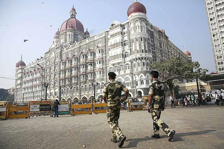 Police officers walk outside the Taj Mahal Hotel, one of the sites of the Mumbai terror attacks - null