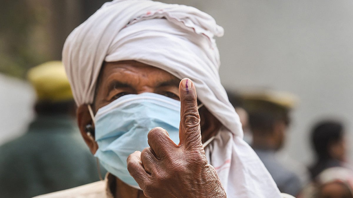 A man shows his inked finger after casting vote at a polling station, during the first phase of UP Assembly elections, in Dadri.