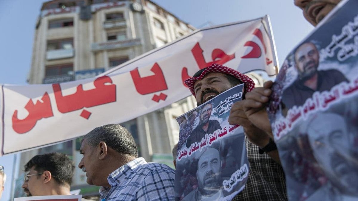 Demonstrators carry posters with pictures of Palestinian Authority outspoken critic Nizar Banat that reads a Martyr of saying the truth in front of an ignorant Sultan, and a banner that reads Abbas, leave, during a rally protesting his death, in the West Bank city of Ramallah