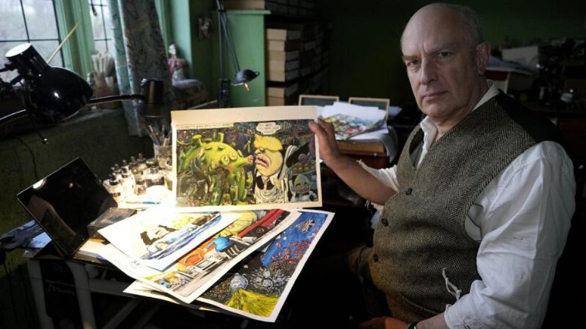 Martin Rowson shows Britain's Prime Minister Boris Johnson cartoons as he poses for a photographer i