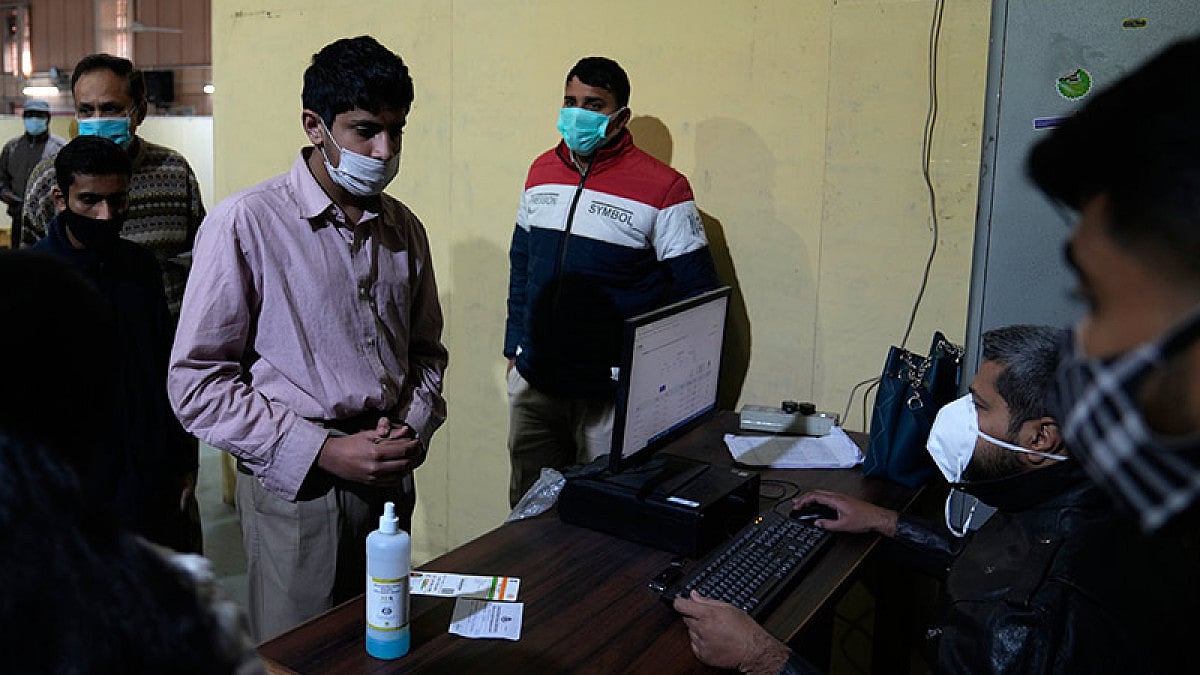 People wait in a queue to register for a Covid-19 vaccination at a makeshift center.