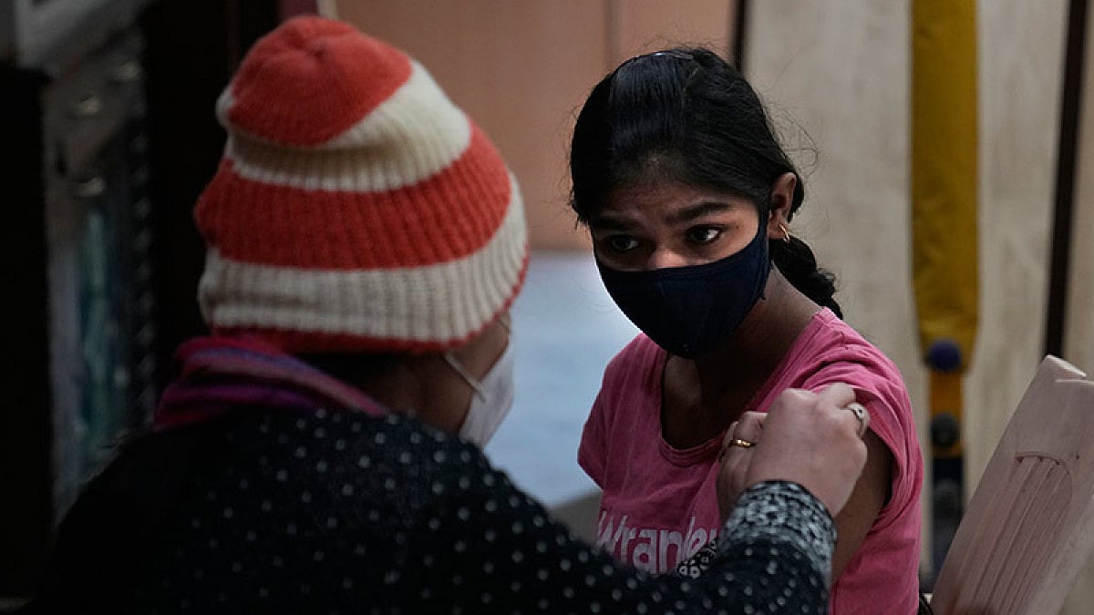 A health worker administers Covid-19 vaccination to a girl, in New Delhi.