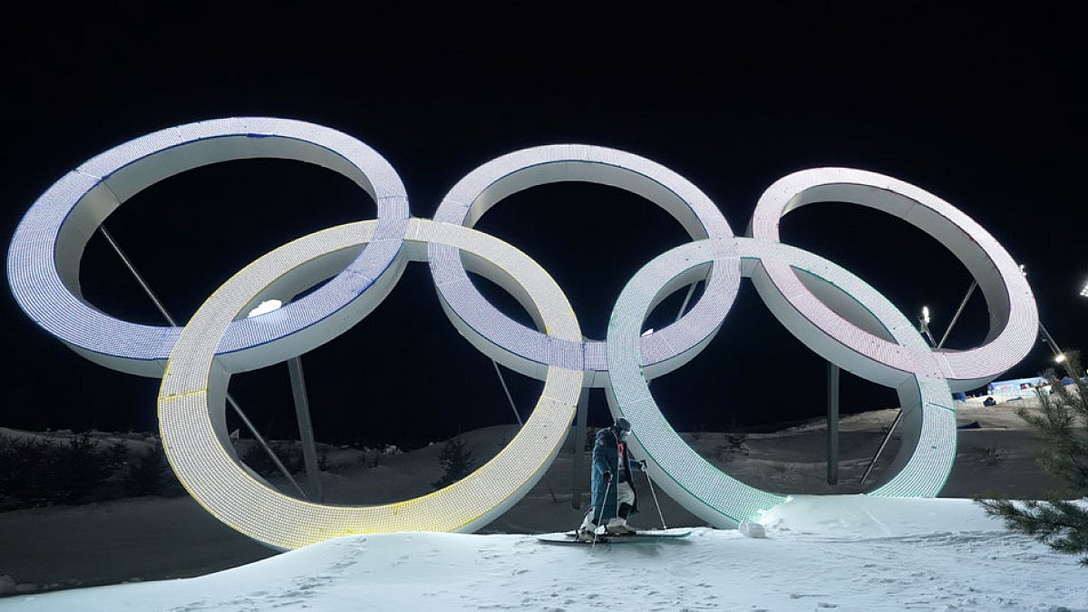 Switzerland's Marco Tade takes pictures by the Olympic Rings in Zhangjiakou, China.