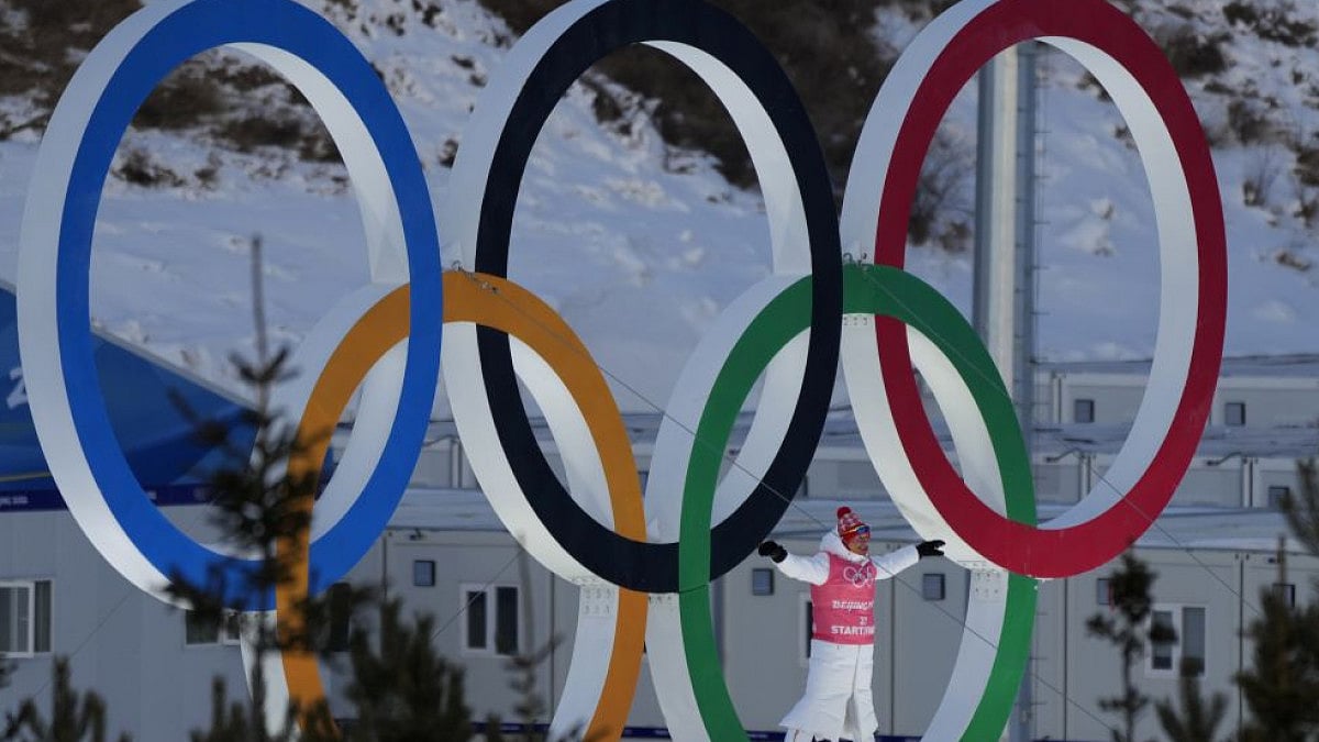 A person stands in Olympic Rings during cross-country skiing training before 2022 Winter Olympics.