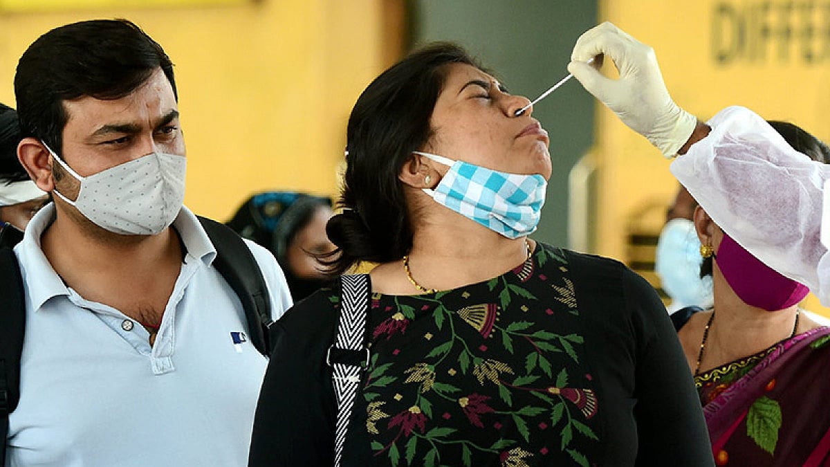 A BMC health worker collects swab sample of an outstation passenger for COVID-19 test.