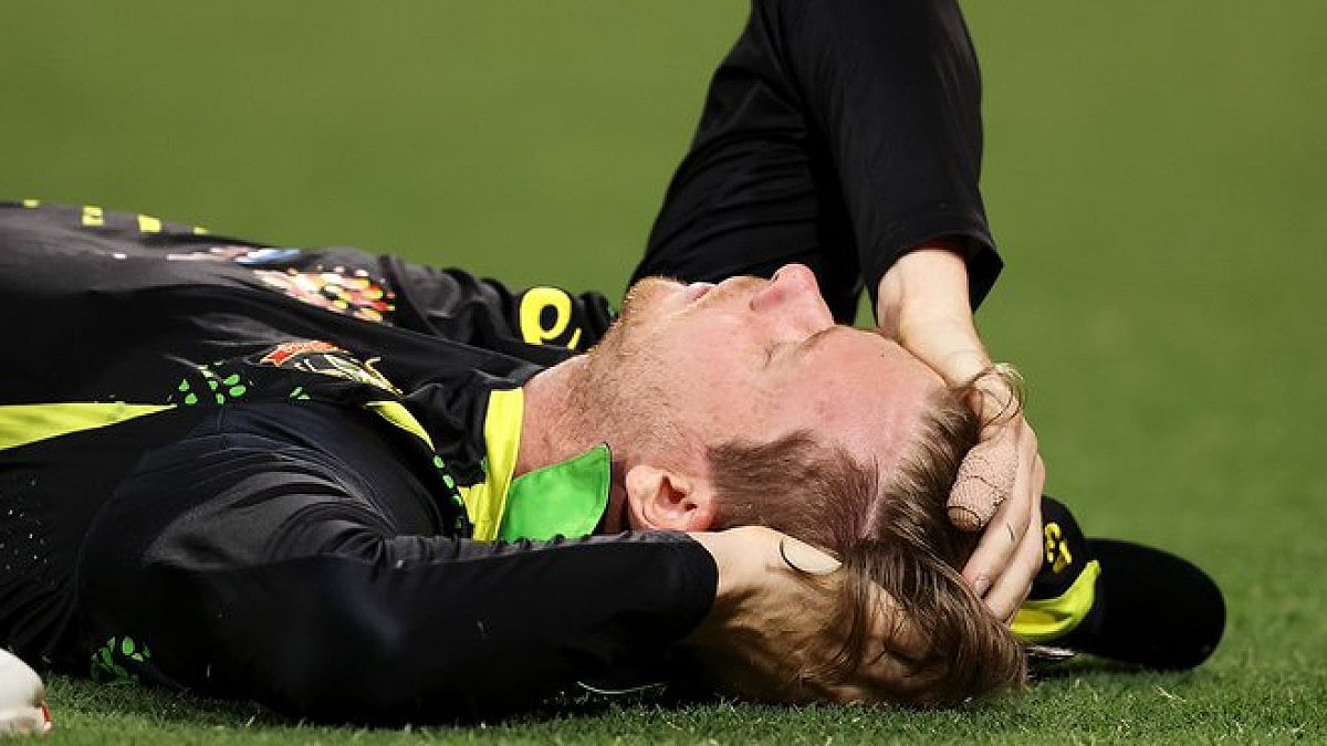 Steve Smith lies on the ground after hitting his head onto the turf while trying to take a catch .