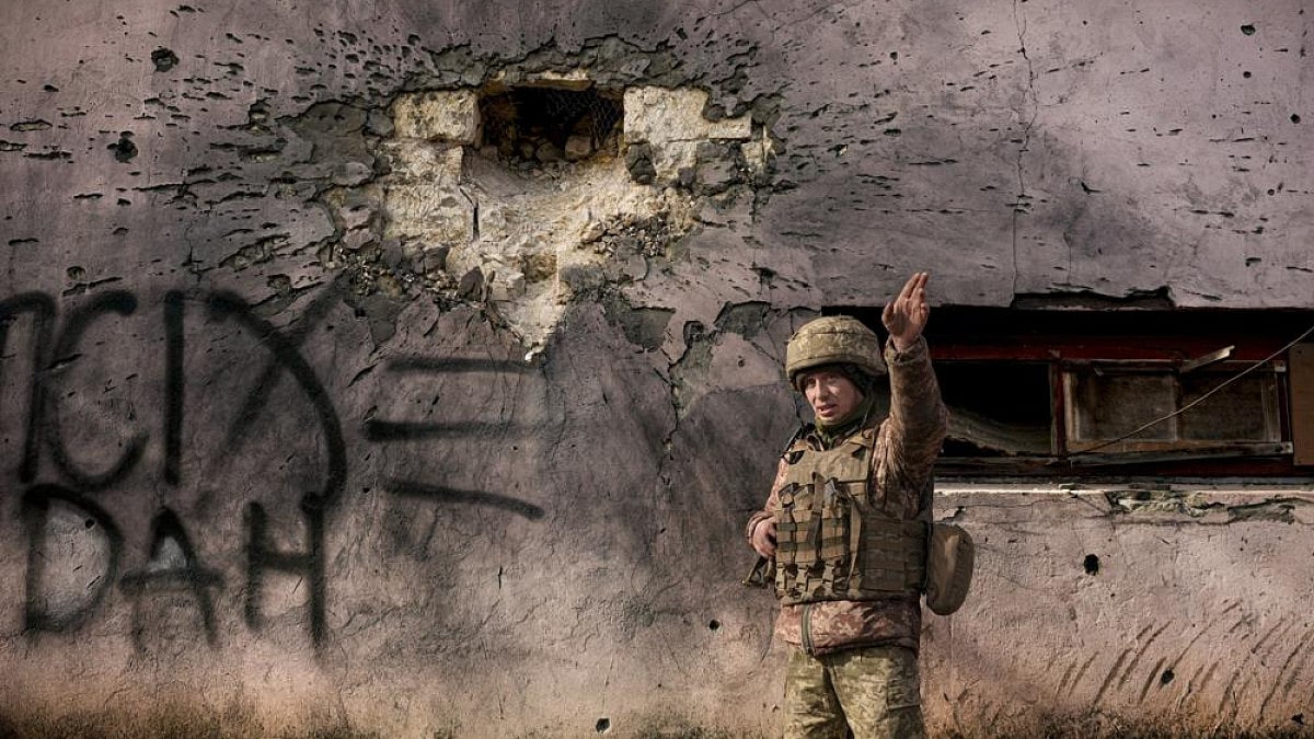 A Ukrainian soldier points to the direction of the incoming shelling in eastern Ukraine.