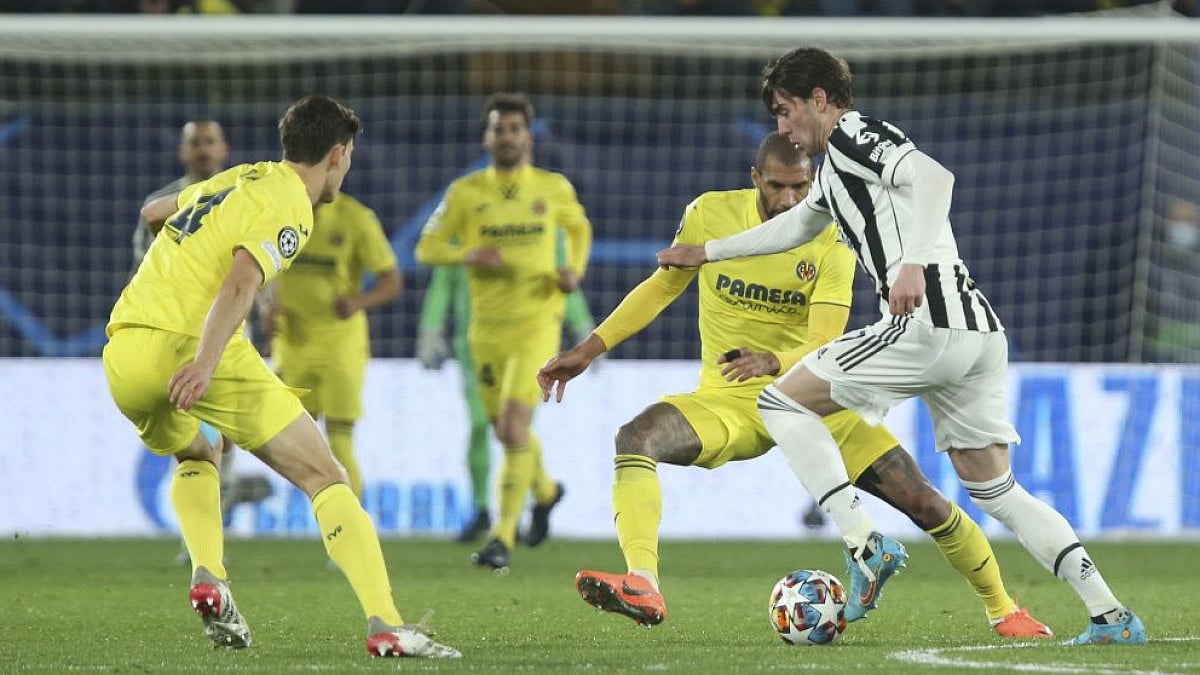 Juventus' Dusan Vlahovic (R) is challenged by Villarreal players during UEFA Champions League match.