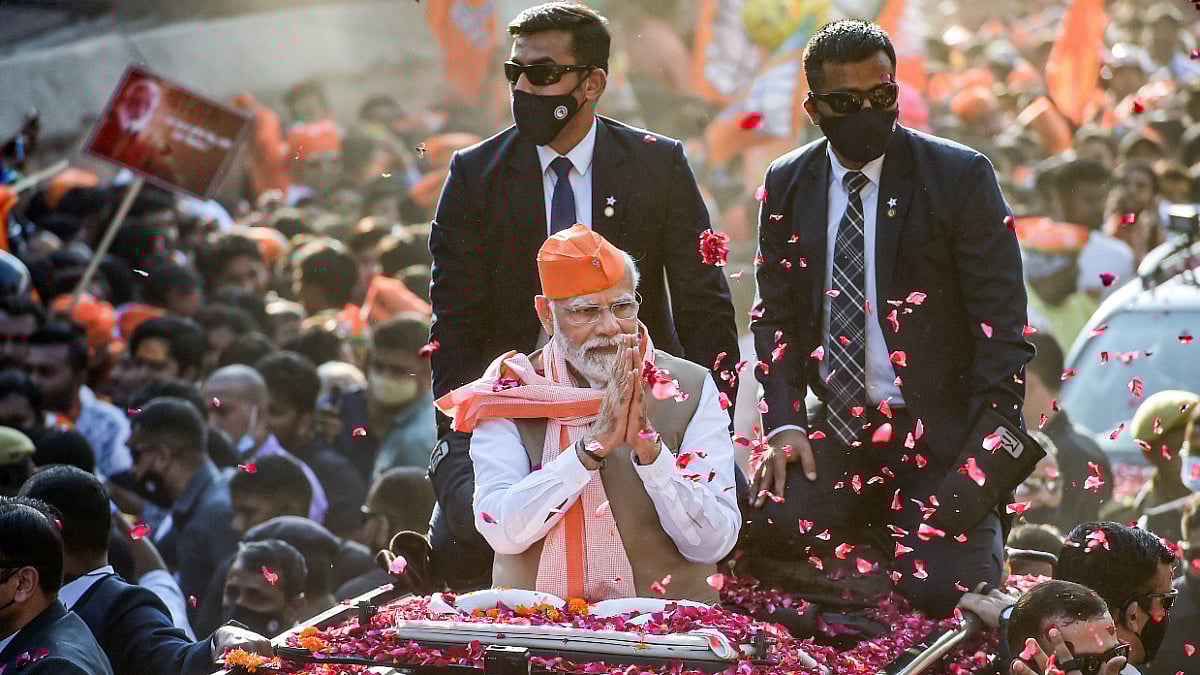 Prime Minister Narendra Modi waves at the supporters during a roadshow for the seventh and last phas