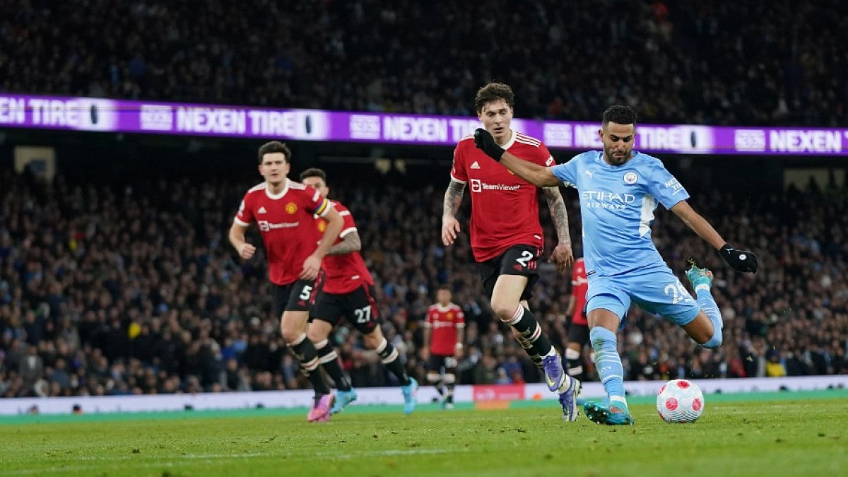 Manchester City's Riyad Mahrez (R) scores against Manchester United in Premier League 2021-22.