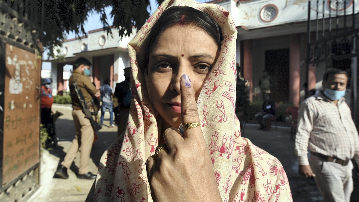 A woman shows her finger marked with indelible ink after casting her vote