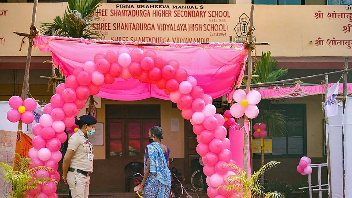 A woman security person stands guard outside a Pink Booth, of Goa Assembly election