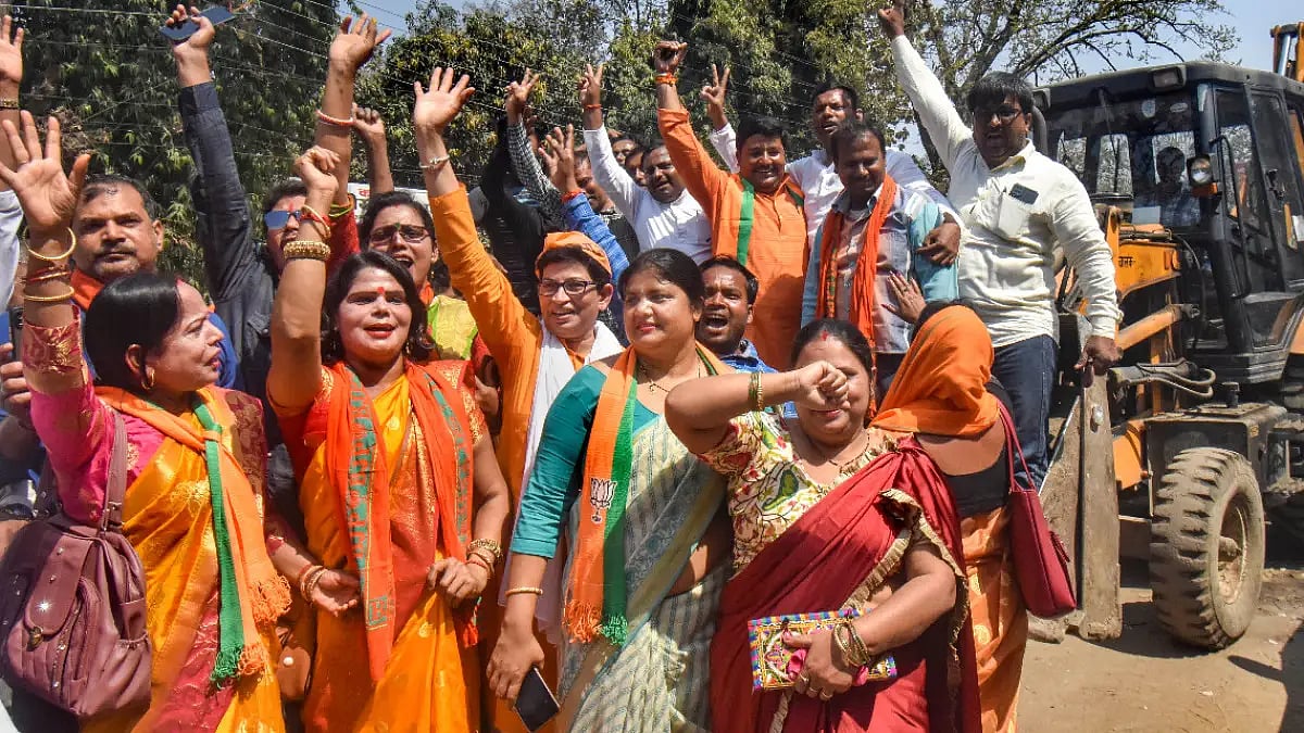 BJP supporters celebrate with a bulldozer, as the party heads to a landslide victory in the UP 