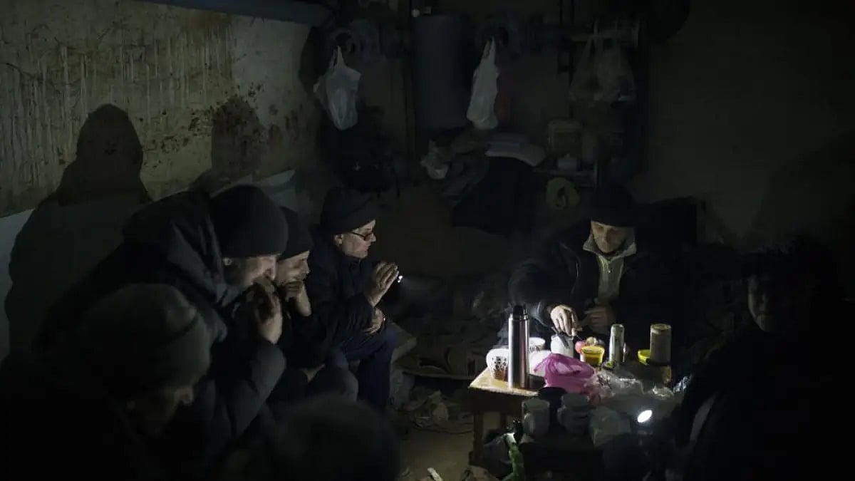 Residents prepare tea as they sit in a basement being used as a bomb shelter in Irpin near Kyiv in U