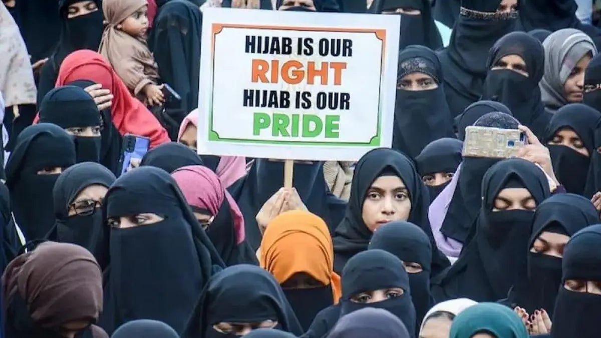A woman in Thane, Maharashtra, holds a placard during a protest in support of Muslim students in the
