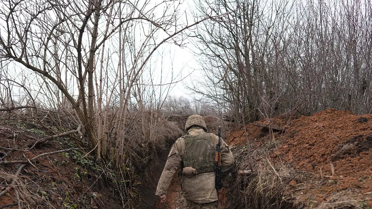 A Ukrainian serviceman in a trench at his position at the line of separation at Ukraine territory