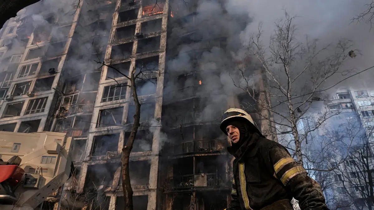 A firefighter walks outside a destroyed apartment building after a bombing in a residential area 