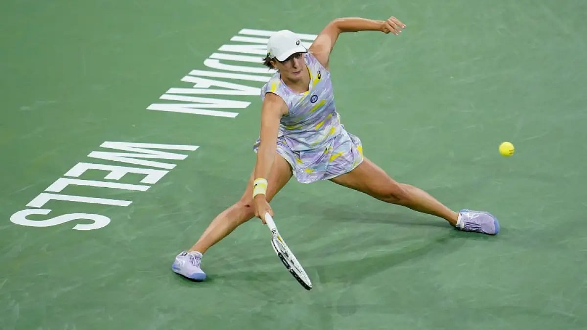 Iga Swiatek returns a shot to Simona Halep at Indian Wells Masters 2022.