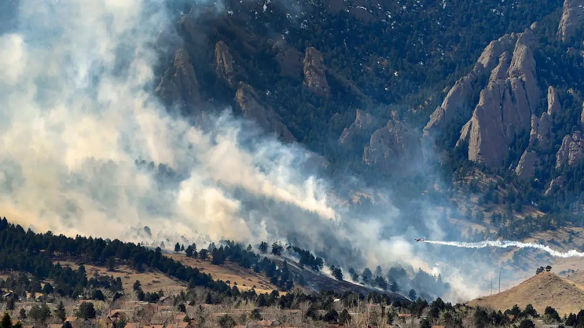 A single engine air tanker drops water on the NCAR fire as it burns in the foothills 