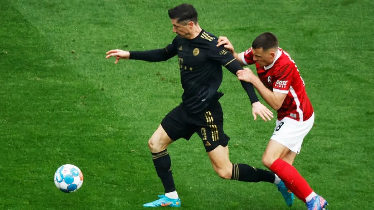 Bayern Munich's Robert Lewandowski (L) Freiburg's Maximilian Eggestein challenge for the ball.
