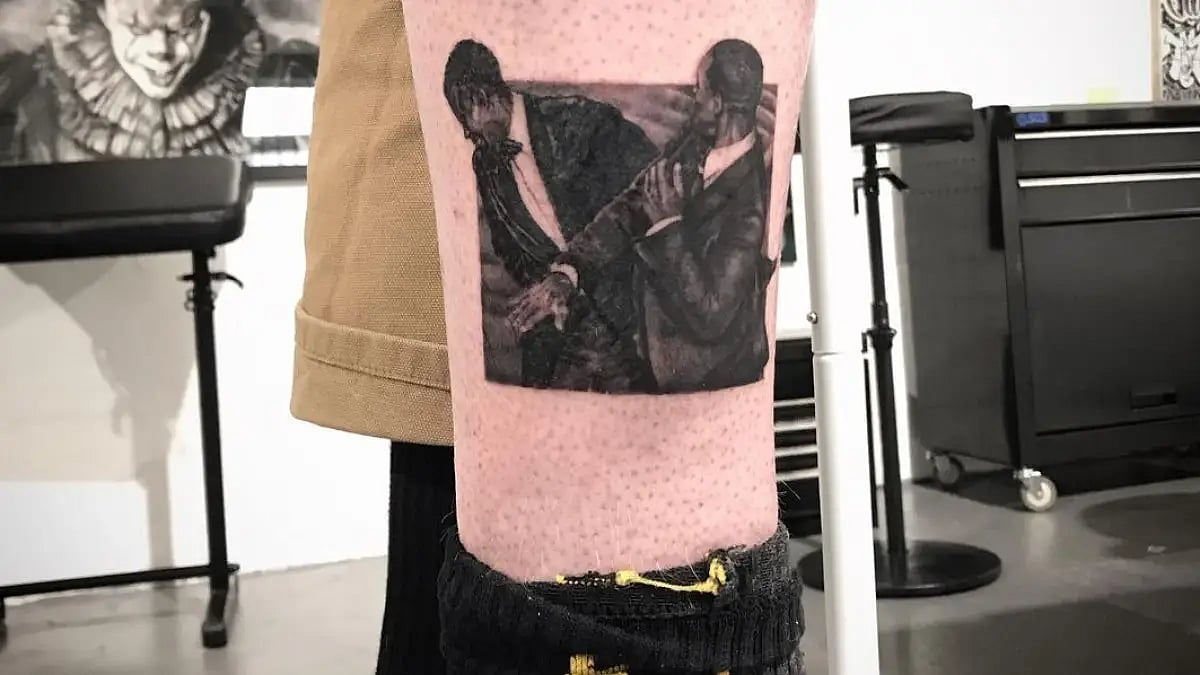 The tattoo of Will Smith slapping Chris Rock on a person's leg.