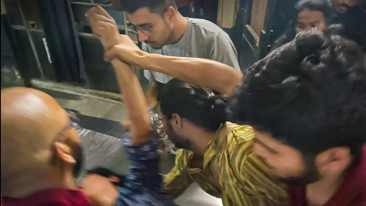 Student make an injured student lie down after a clash between students unions over non-veg food