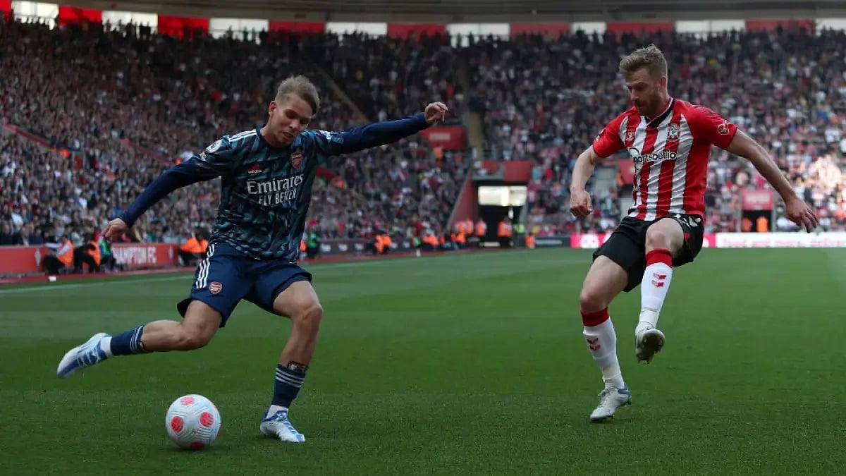 Arsenal's Emile Smith Rowe (L) crosses the ball past Southampton's Stuart Armstrong in an EPL tie. 