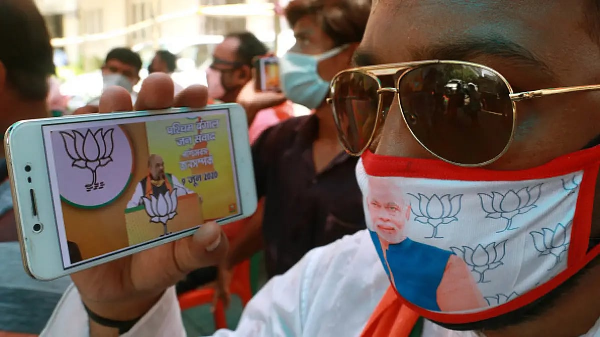 A BJP supporter watching Home Minister Amit Shah speaking at a virtual rally