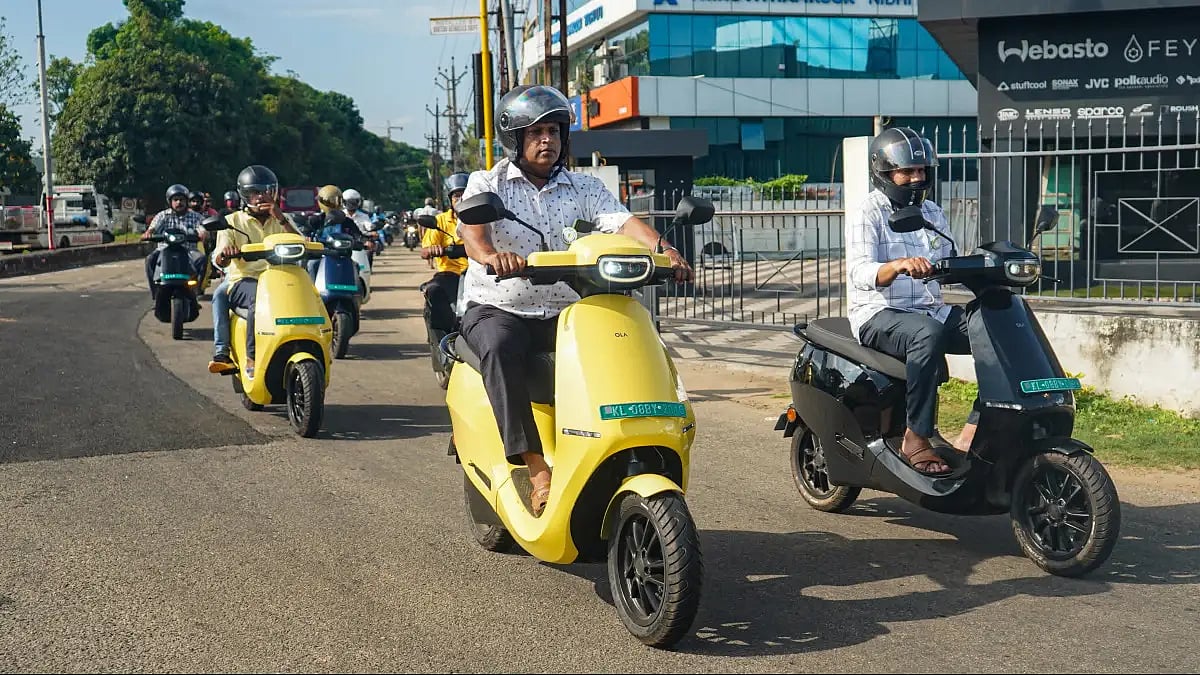 People riding Ola scooters