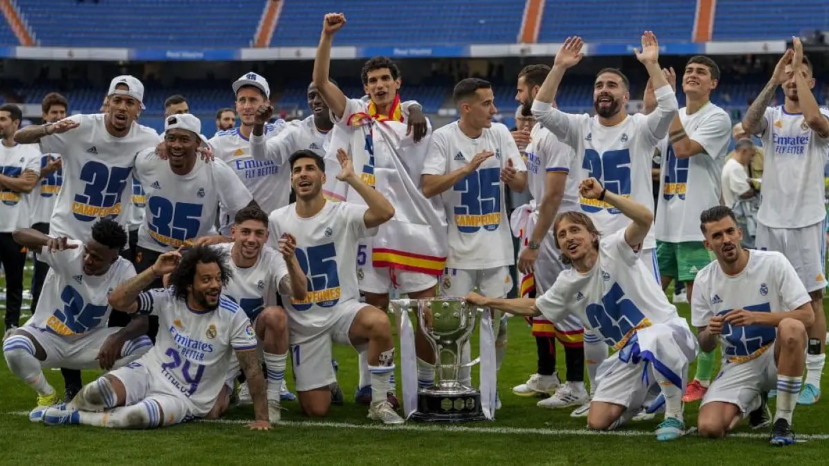 Real Madrid players pose with La Liga trophy after match against Espanyol on Saturday.