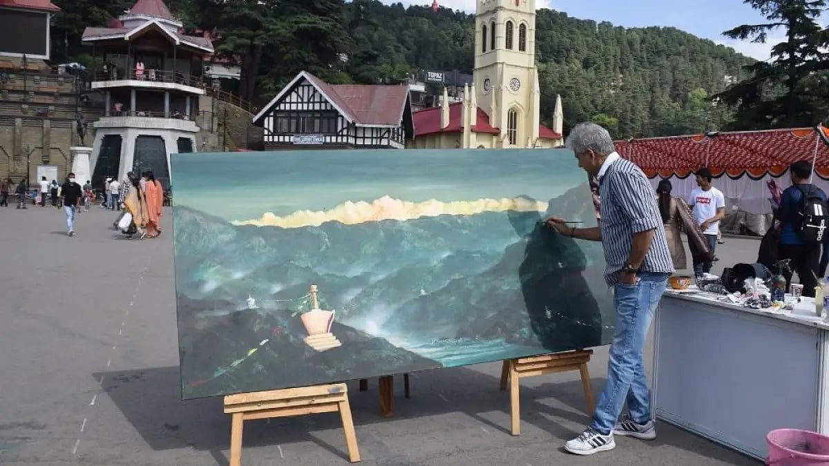 K K Gandhi, an award-winning painter from Jammu, working on his art at Shimla's Ridge.
