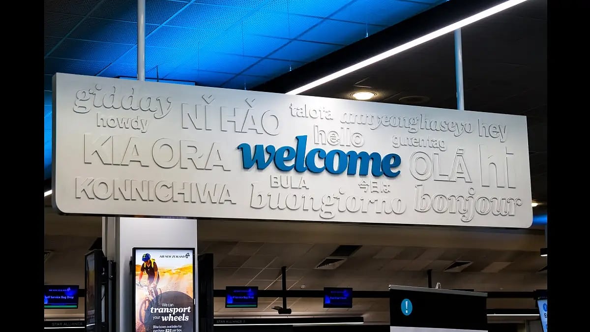 A sign welcoming travellers in different languages at Auckland International Airport