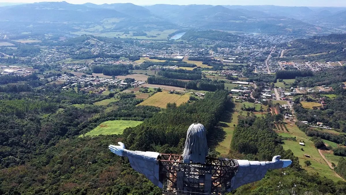 A panoramic view of the town of Encantado over the shoulders of the statue of Christ the Protector