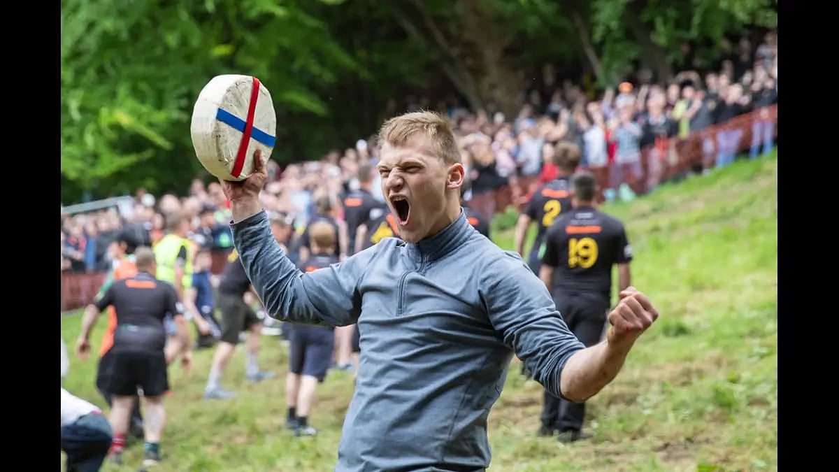 Canadian Mark Kit celebrates his win at the 2019 Cooper's Hill cheese-rolling event