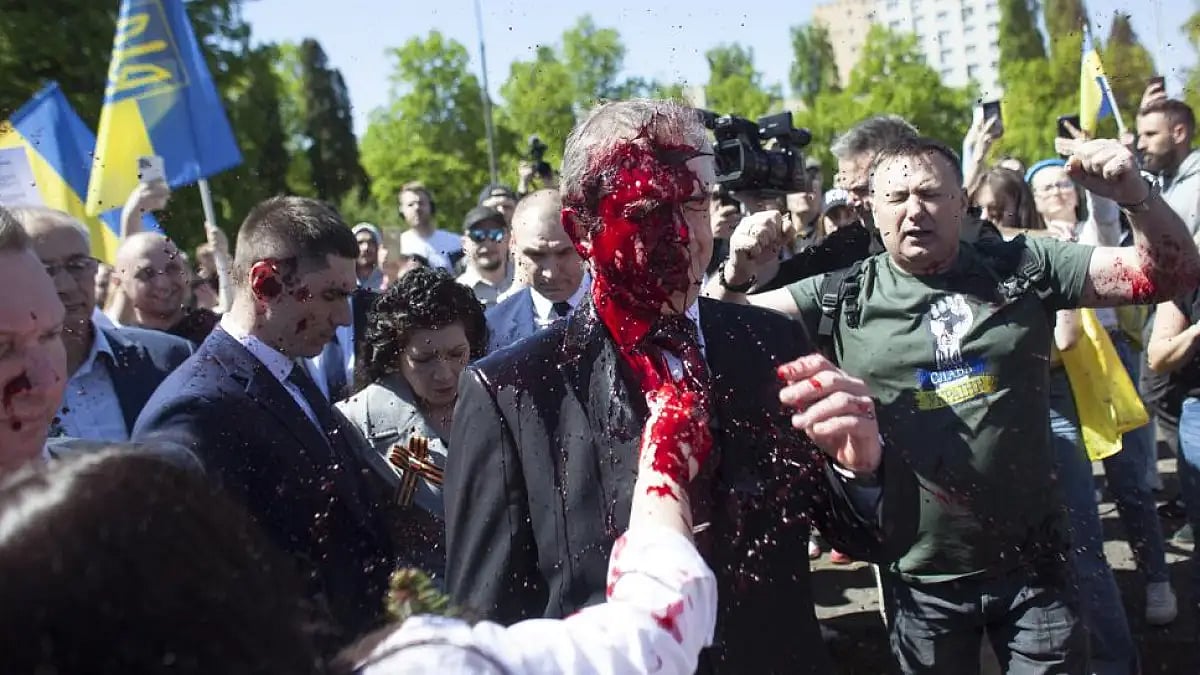 Protesters thrown red paint on the Russian ambassador as he arrived at a cemetery in Warsaw