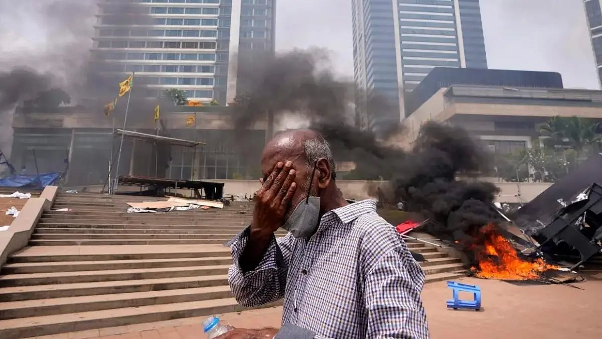A Sri Lankan man reacts to tear gas as he walks past the anti-government protest's site outside pres