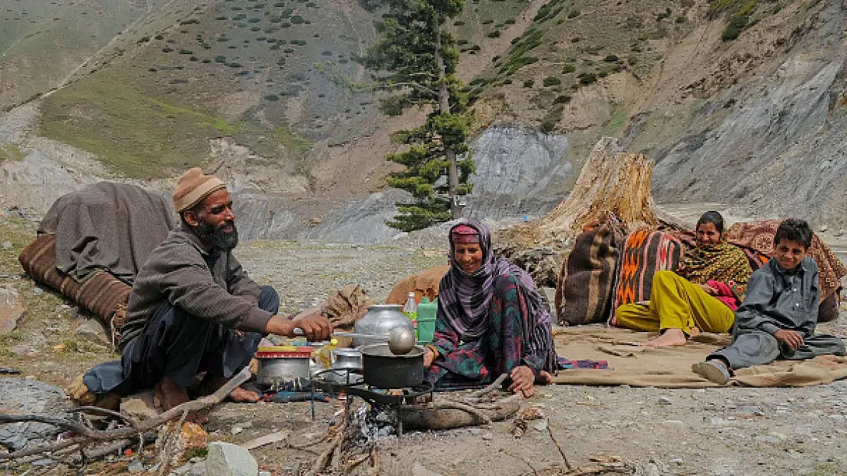 A member of the nomad Bakerwal community prepares tea as others rest in the mountains in Srinagar.