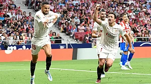 Youssef En-Nesyri (L) celebrates after scoring against Atletico Madrid in a La Liga 2021-22 match.