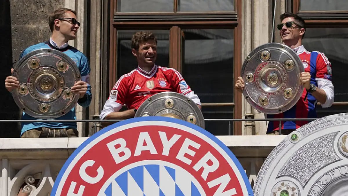 Bayern Munich's Manuel Neuer, from left, Thomas Mueller and Robert Lewandowski stand on the balcony of the town hall at Marienplatz square celebrating the 31th Bundesliga title. May 15, 2022.
