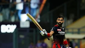 Virat Kohli raises his bat after reaching his fifty against Gujarat Titans in an IPL 2022 tie.