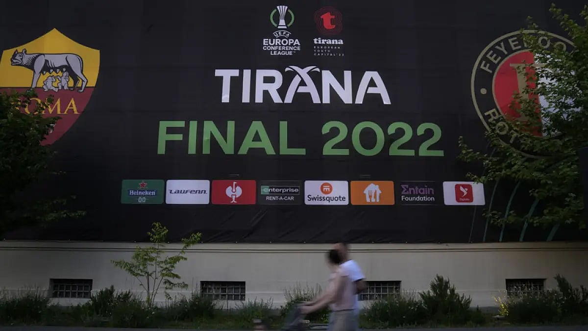 People walk past a Europa Conference League poster, in downtown of Tirana, Albania on May 24, 2022.