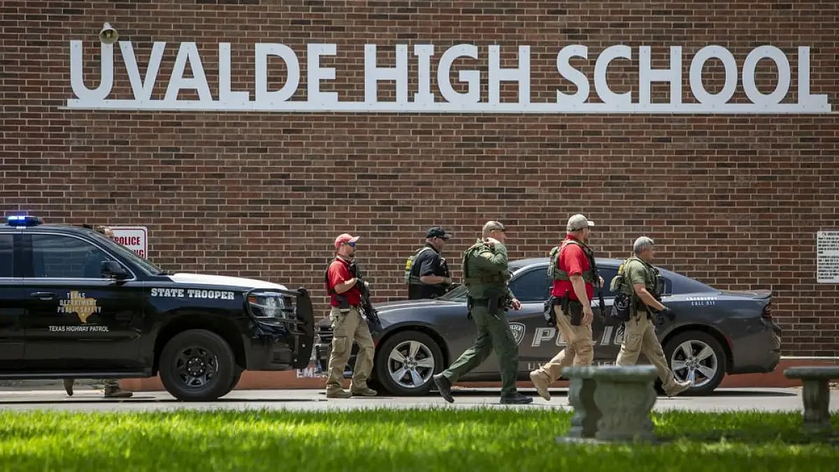 Law enforcement personnel walk outside Uvalde High School after shooting a was reported.