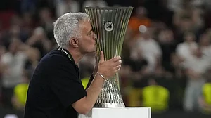 AS Roma's coach Jose Mourinho kisses the Europa Conference League trophy.