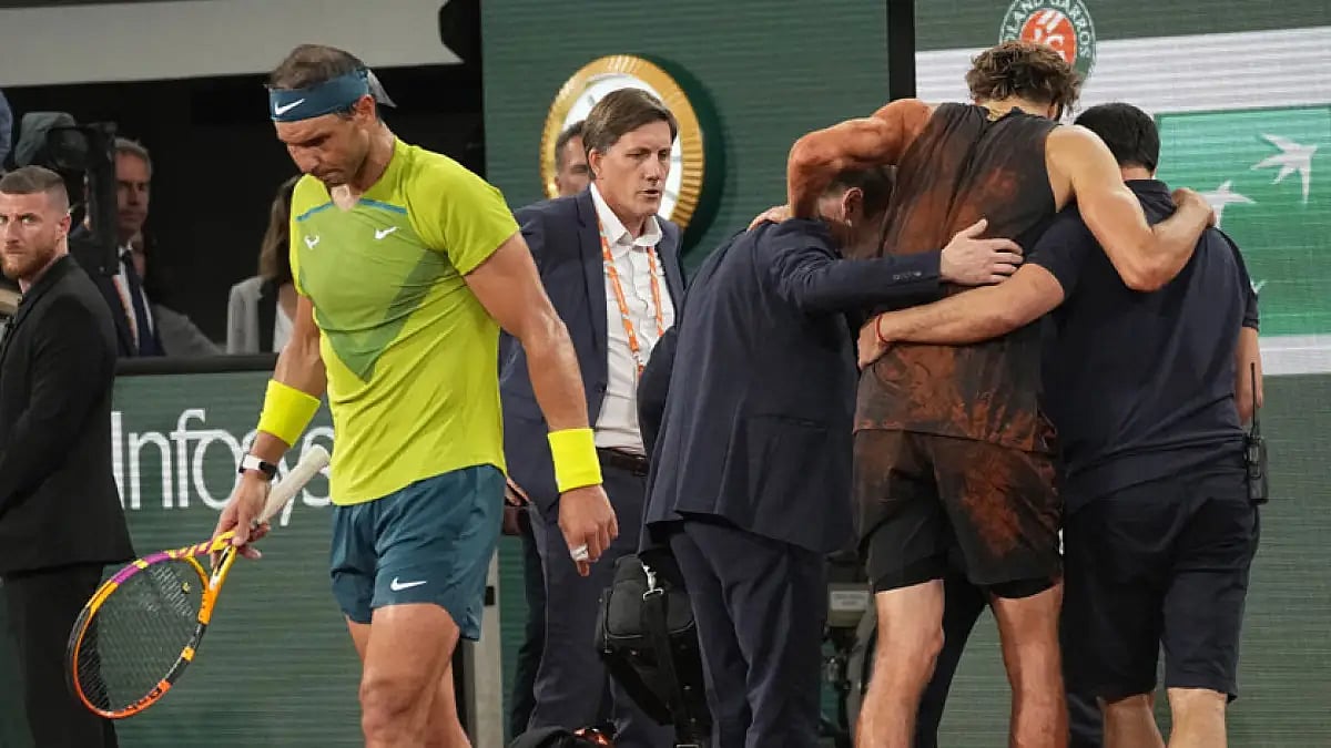 Rafael Nadal walks back as Alexander Zverev is being helped to sit on a wheelchair during their French Open semi-final match.