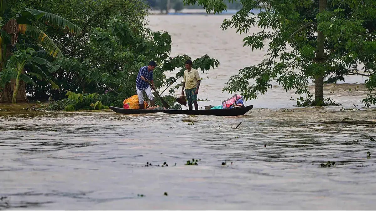 Villagers use a boat to move from a flooded area to safer places after rain at a village in Nagaon