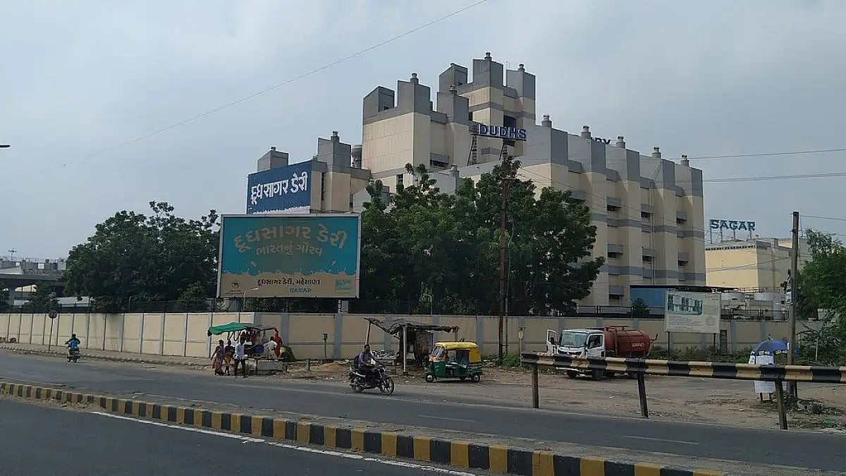 A security guard at the Dudhsagar Dairy was injured when a former Vice Chairman's son opened fire 