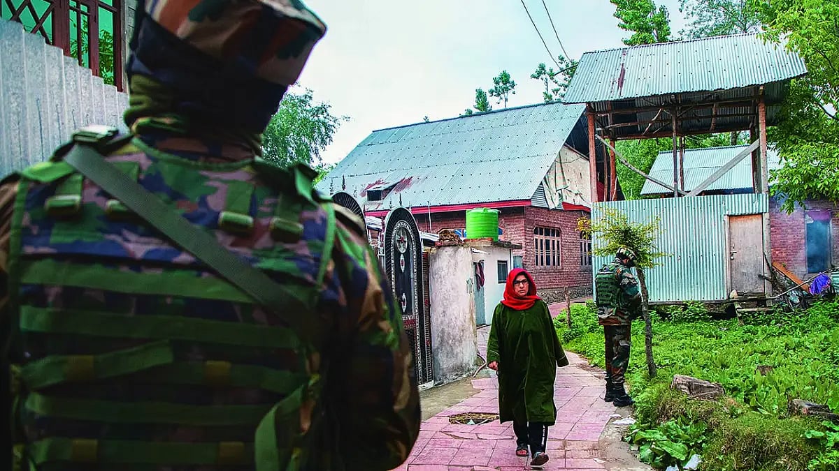 Shadow of the gun A Kashmiri woman walks past soldiers in Baramulla district.