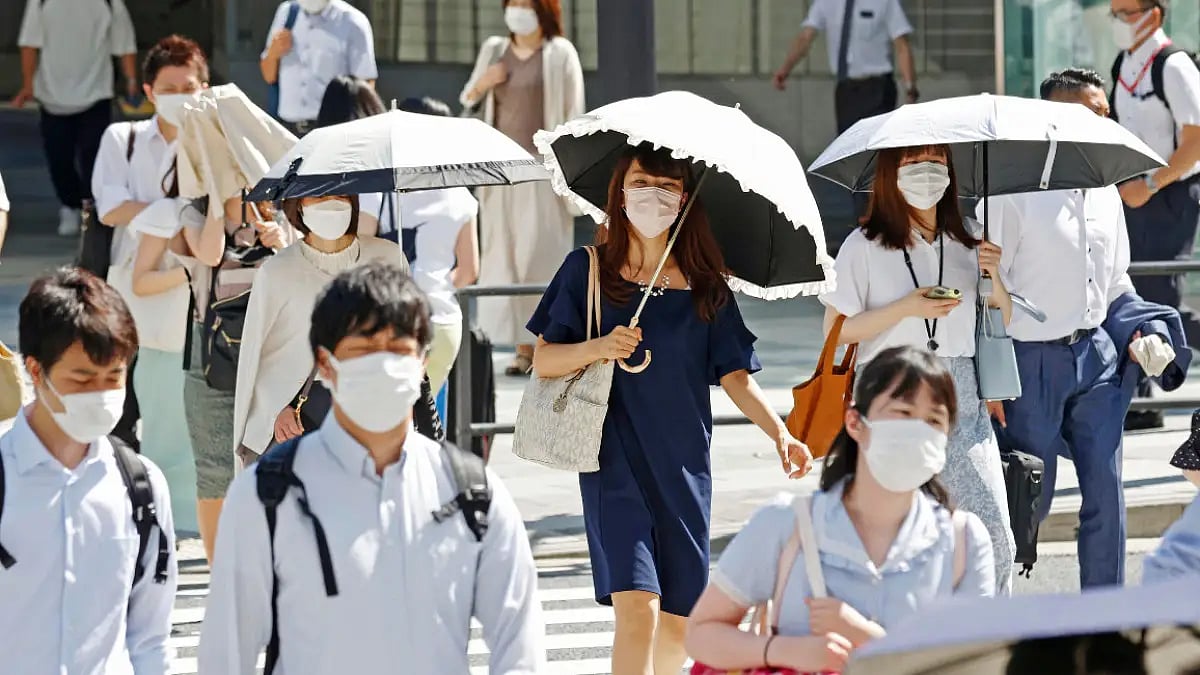 People holding parasols cross an intersection in Tokyo - null