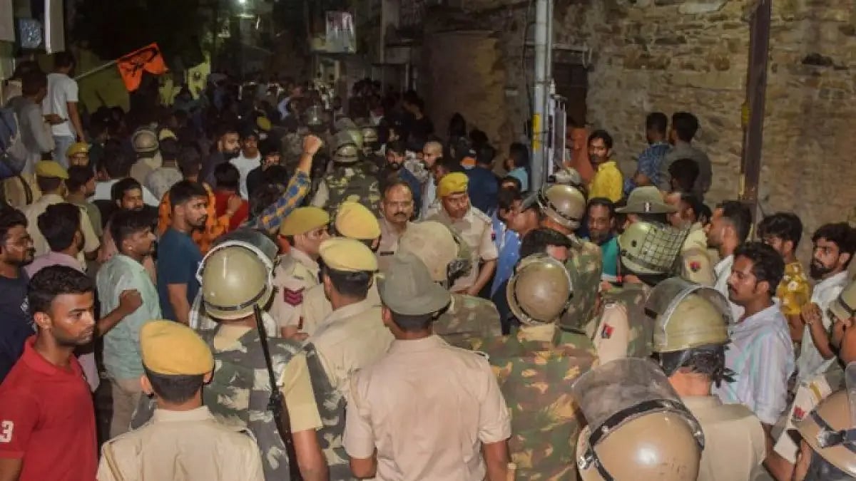 Police at the scene of crime after the murder of a tailor by two men.